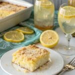 Tangy lemon cream cheese dump cake topped with whipped cream and lemon slices.